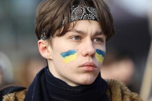 portret nastoletniego chłopaka, na policzkach ma namalowane flagi ukrainy