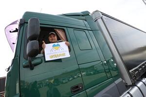 kierowca siedzi w ciężarówce i trzyma logo akcji "gdańsk pomaga Ukrainie"