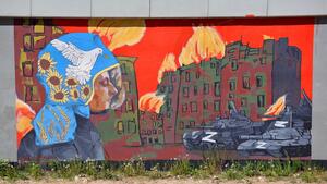 Mural: postać strażaka, który w obecnej sytuacji na Ukrainie, musi mierzyć się nie tylko z żywiołem ognia, wywołanym przez bomby zrzucone przez najeźdźców, ale również z napastnikami pod postacią czołgów, które utrudniają mu ratowanie ludzkiego życia