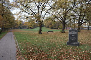 Park, po środku kamienna tablica z napisami i wyrysowaną mapką 