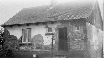 białoczarne zdjęcie przedstawiające dawną wiejską chatę jaką budowano w okresie międzywojnia w dwudziestym wieku
