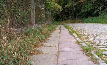 stary wysłużony chodnik z połamanymi płytami chodnikowymi