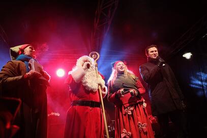 Dwie kobiety, święty Mikołaj i mężczyzna (Piotr Grzelak) na scenie. Zdjęcie zrobione od dołu