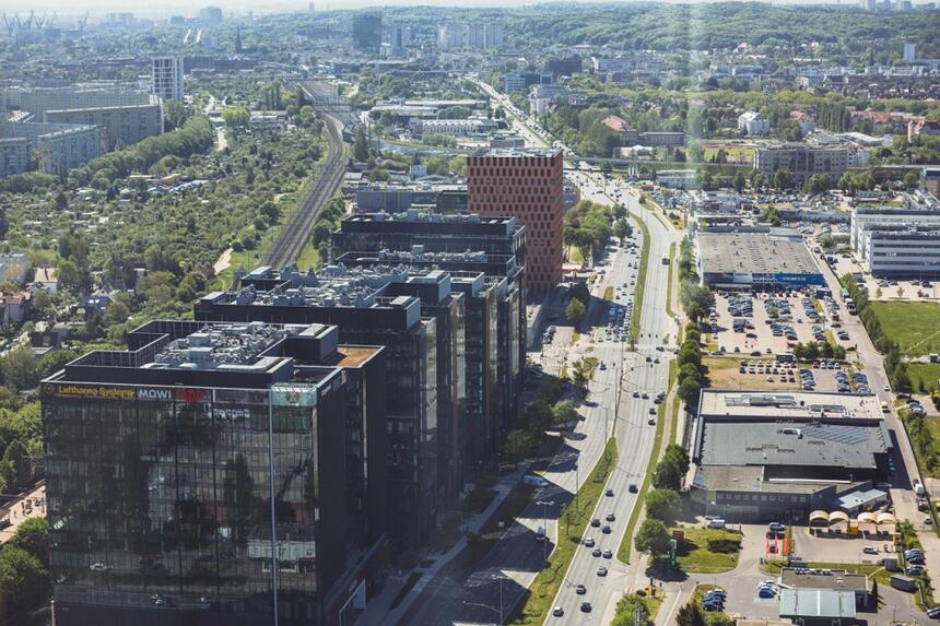 perspektywa ulicy widoczna w szerokiej perspektywie i z bardzo wysoka, po lewej szereg wysokich biurowców, po prawej zabudowania zupełnie niskie