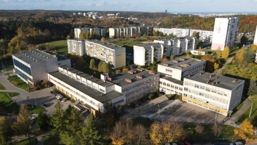 zdjęcie z drona, na którym widać kilka połączonych budynków szkoły podstawowej, w tle widać wysokie bloki mieszkalne