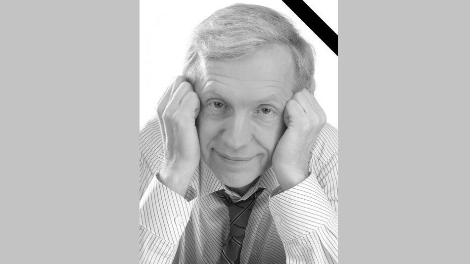 Czarno-białe zdjęcie: twarz starszego siwego mężczyzny z zaciśniętymi dłońmi opartymi o policzki