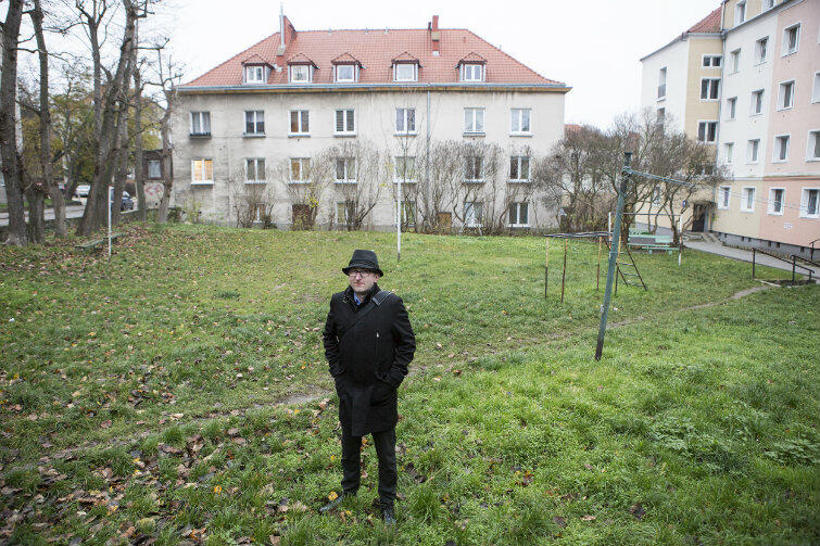 Marcin Kochanowski na podwórzu domu, w którym mieszka.