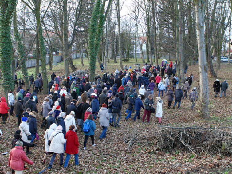 Uczestnicy niedzielnej wycieczki po Chełmie przechodzą przez teren starego cmentarza nieopodal kościoła Podwyższenia Krzyża.