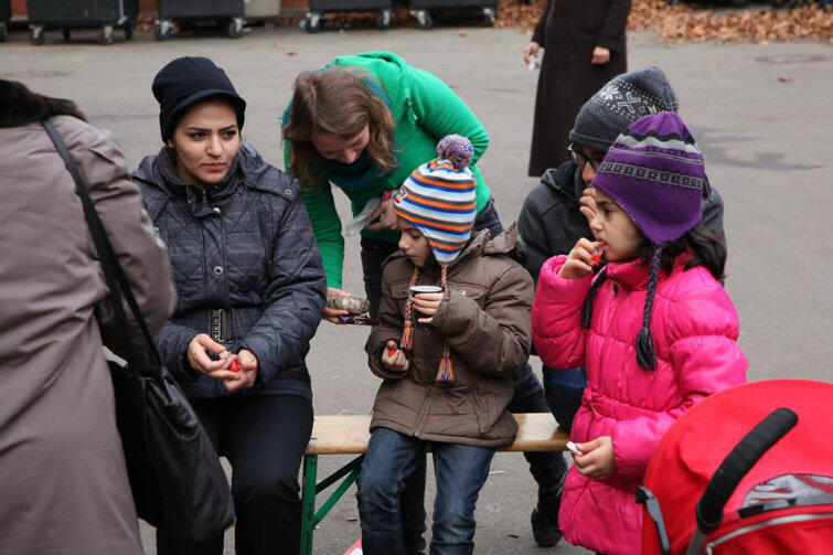 Anna Alboth częstuje małych uchodźców słodyczami.
