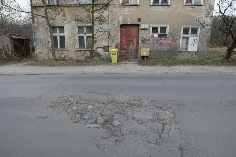 Nie tylko dziury i pofałdowania, ale także fragmenty wystającego bruku to cechy nawierzchni tej ulicy.