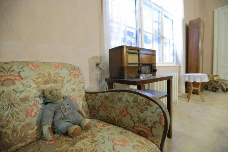 Rekonstrukcja przedwojennego mieszkania w Muzeum II Wojny Światowej. Mieszkała w nim 9-letnia Halinka. Na kanapie jej miś. Za oknem - wojna światowa. 