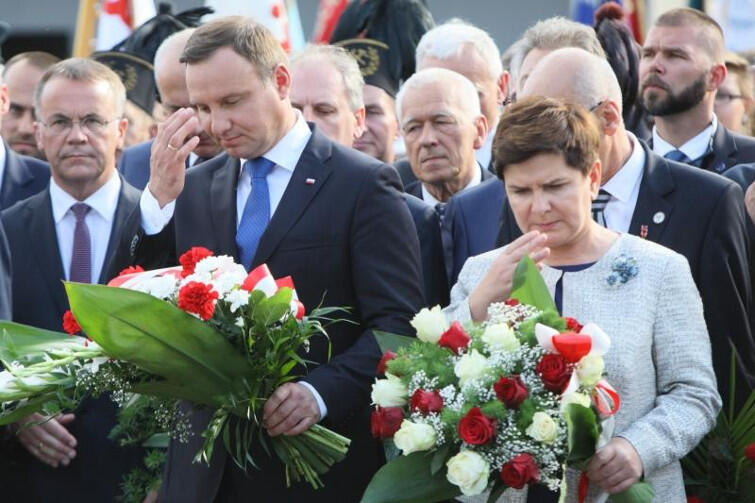Prezydent RP Andrzej Duda i premier rządu RP Beata Szydło robią znak krzyża przed bramą nr 2. Czy PiS uzna Wałęsę za bohatera czy za agenta SB Bolka, jak mówi o nim wielu polityków tej partii?