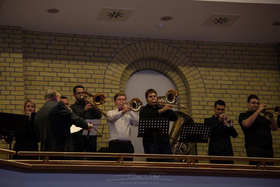 Zespół muzyków grających na instrumentach dętych blaszanych wykonuje intradę podczas inauguracji na Akademii Muzycznej w Gdańsku.