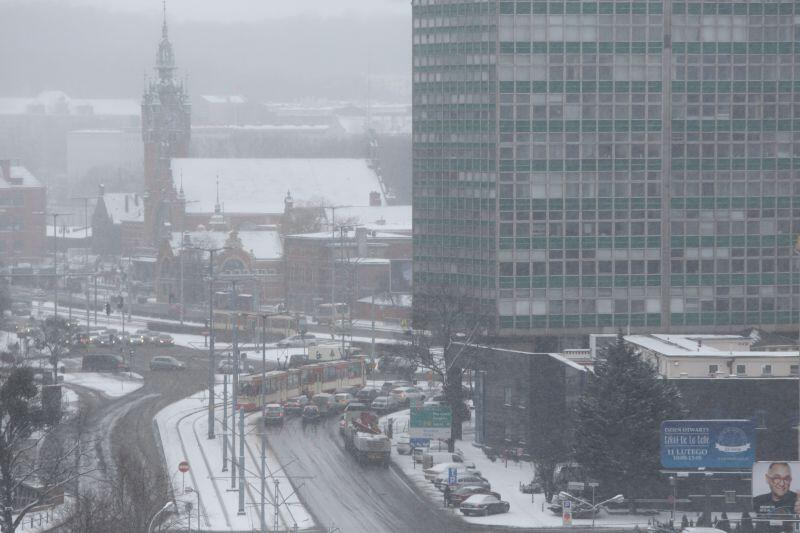 Sytuacja pod popularnym Zieleniakiem (w tle - gmach dworca kolejowego Gdańsk Główny). Opady śniegu nie są intensywne, dzięki czemu na głównych drogach możliwe jest utrzymanie bezpiecznej czarnej jezdni