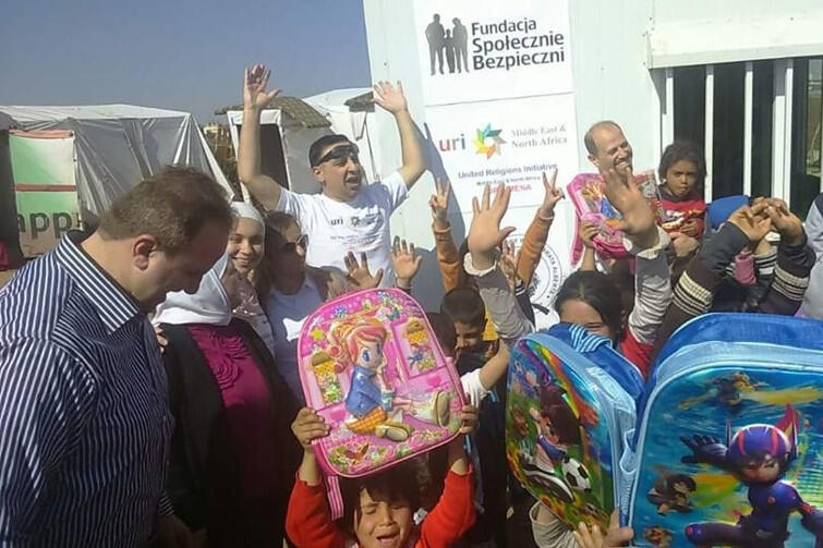 Syryjskie dzieci i ich rodzice przed kontenerową szkołą na przedmieściach Ammanu. Dzieci, dzięki Waszej hojności, dostały też plecaki! 