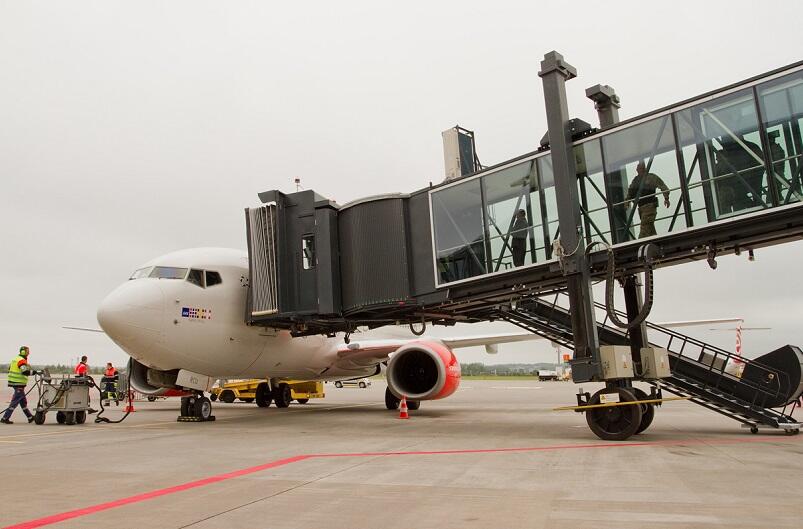 Pasażerowie Portu Lotniczego Gdańsk korzystający z rękawa samojezdnego przy terminalu pasażerskim T2