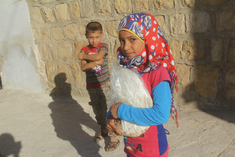 Dzieci z chlebem wypieczonym w piekarni wspieranej przez PAH. Syria, prowincja Idleb, wrzesień 2016 r.