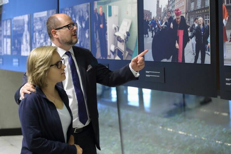 Prezydent Gdańska Paweł Adamowicz pokazuje córce jedno ze zdjęć na wystawie Ślady w ECS poświęconej życiu arcybiskupa Tadeusza Gocłowskiego