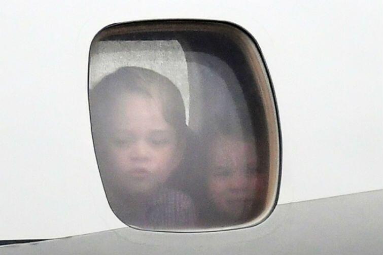 Warszawa, 17 lipca. Małe książątka - Charlotte i George - patrzą przez szybę samolotu na płytę lotniska