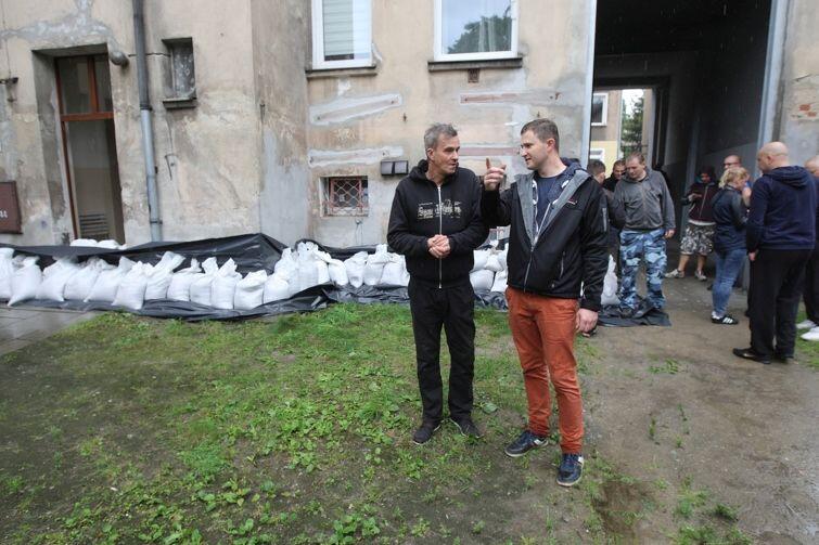 Wiceprezydent Piotr Grzelak (z prawej) rozmawia z mieszkańcami na podwórku przy ul. Wallenroda we Wrzeszczu, gdzie ułożono worki z piaskiem