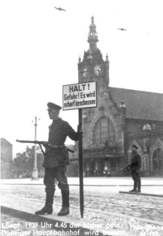 Posterunek niemiecki przed dworcem kolejowym w Gdańsku. Widoczni uzbrojeni żołnierze pilnujący dworca z tablicą w języku niemieckim 'Stop! Niebezpieczeństwo zastrzelenia'