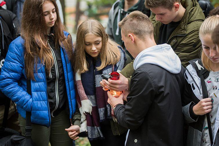 Cmentarz Srebrzysko. Młodzież zapala znicze na grobach żołnierzy AK