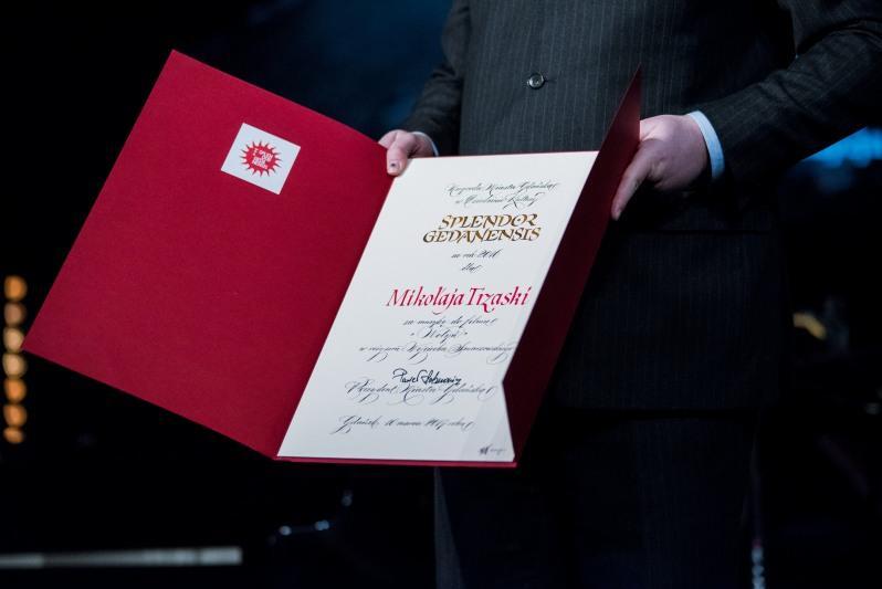 Każdy z laureatów otrzymuje pamiątkowe dyplomy, na zdjęciu dyplom dla Mikołaja Trzaski za rok 2016