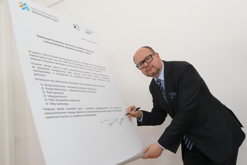 Paweł Adamowicz, prezydent Gdańska i przewodniczący zarządu Obszaru Metropolitalnego G-G-S składa podpis pod deklaracją
