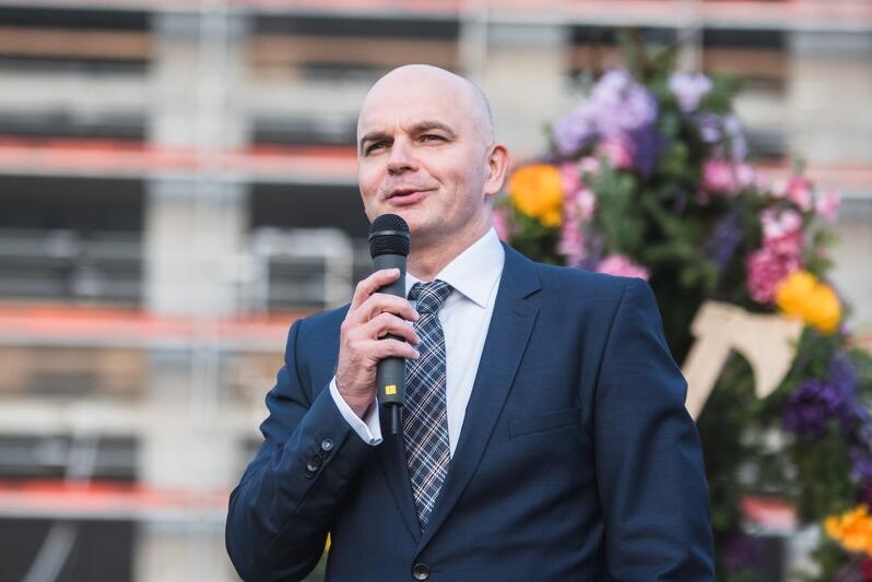 Sławomir Gajewski, prezes zarządu firmy Torus, za nim - wiecha dla pierwszego etapu Officyny