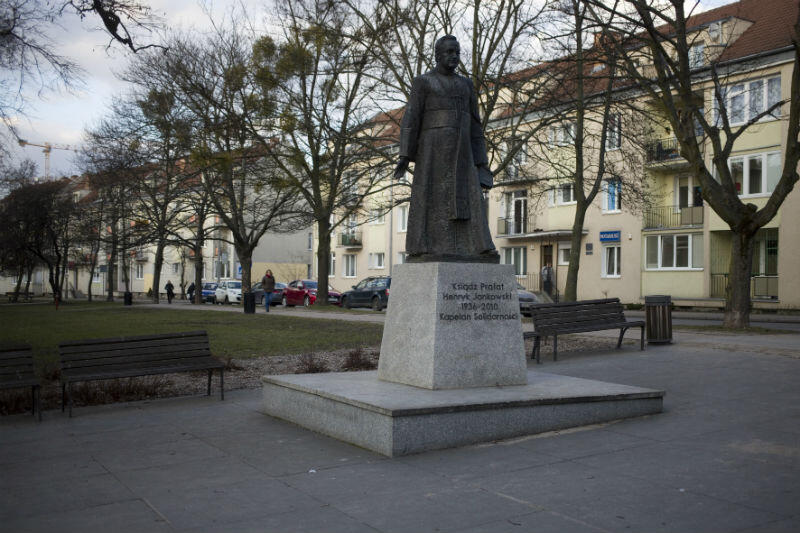 Pomnik ks. Jankowskiego stoi między ulicami Mniszki i Stolarską