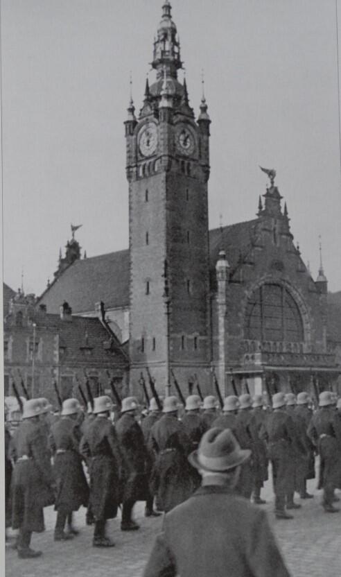 Niemcy zajmują Gdańsk. Oddziały Rzeszy wkraczają do miasta. Żołnierze jednej z nazistowskich formacji militarnych paradują przed Dworcem Głównym 