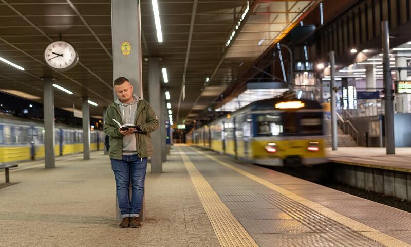 Marcin na stacji SKM Wrzeszcz czyta książkę Witolda Beresia i Krzysztofa Burnetko „Kapuściński Nie ogarniam Świata”