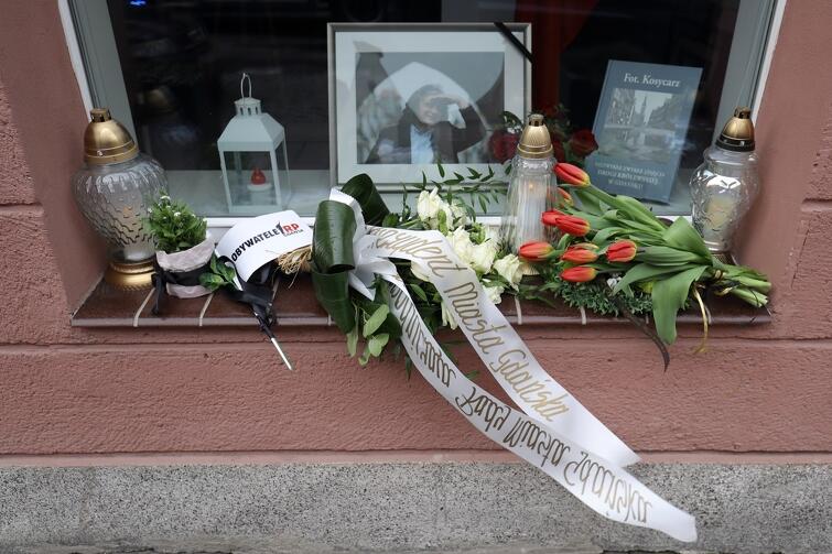 Wiązanka białych róż - od prezydent Aleksandry Dulkiewicz. Inne osoby dla upamiętnienia Macieja Kosycarza również przyniosły kwiaty, a także znicze. Ktoś położył chorągiewkę Obywateli RP 