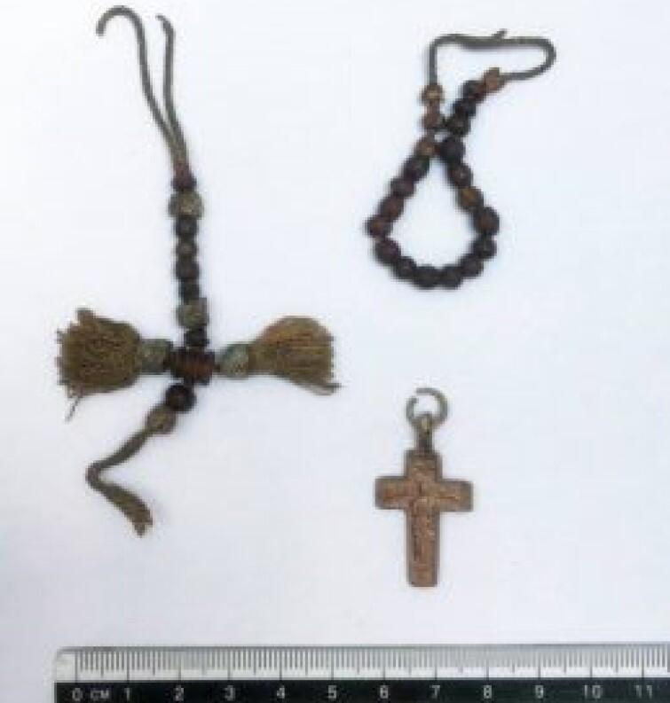 Wśród znalezionych przedmiotów jest krzyżyk, a także różaniec, którego paciorki wykonano z kości i nawleczono na jedwabny sznurek z ozdobnymi frędzelkami