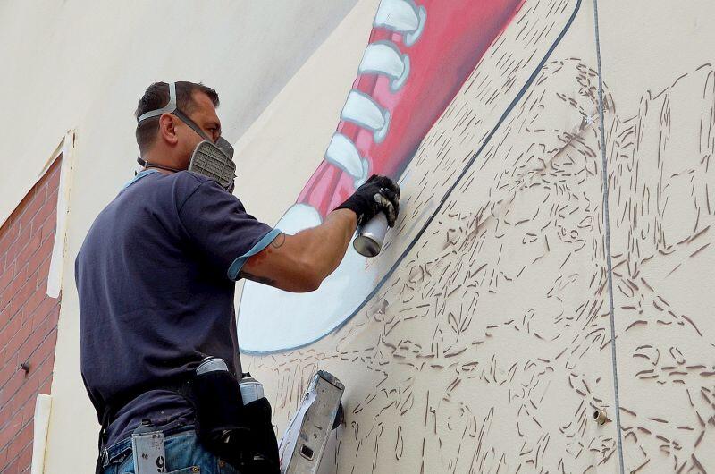 Marek Looney Rybowski w czasie prac nad muralem