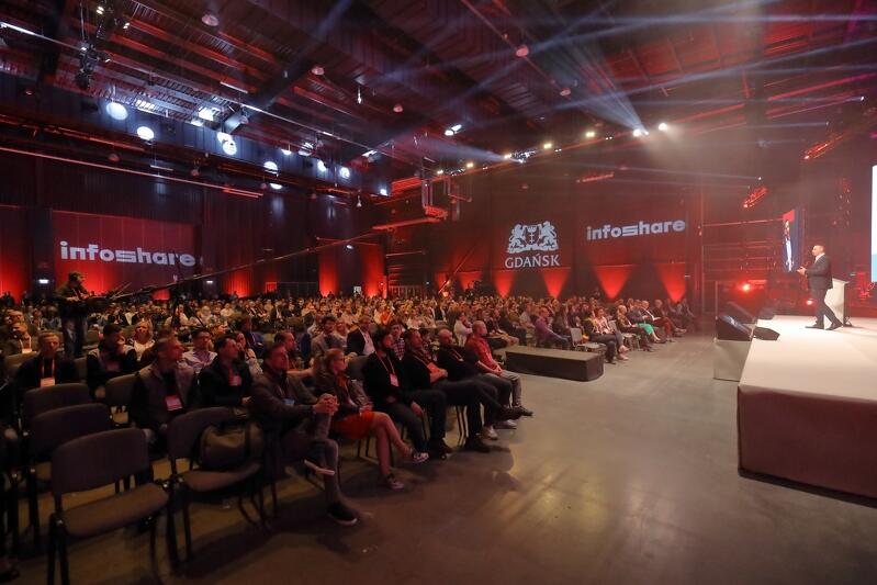 Otwarcie Infoshare 2019, scena Inspire, na scenie otwierający konferencję Grzegorz Borowski prezes zarządu Infoshare zwraca się do tłumu ludzi siedzącego na krzesłach w hali Amber Expo w Gdańsku, w której odbywa się otwarcie