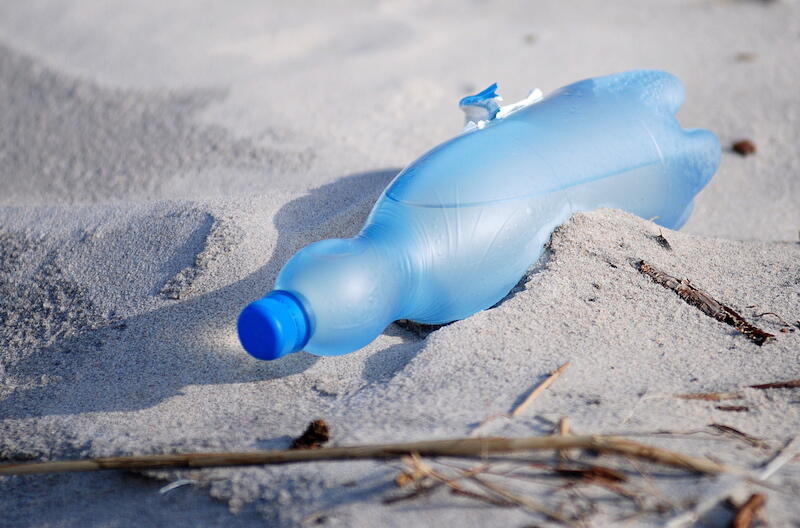 Plastikowe butelki na brzegu morza to widok, który skłania do refleksji, bo niebieski element nie pasuje do pięknego krajobrazu na tym zdjęciu