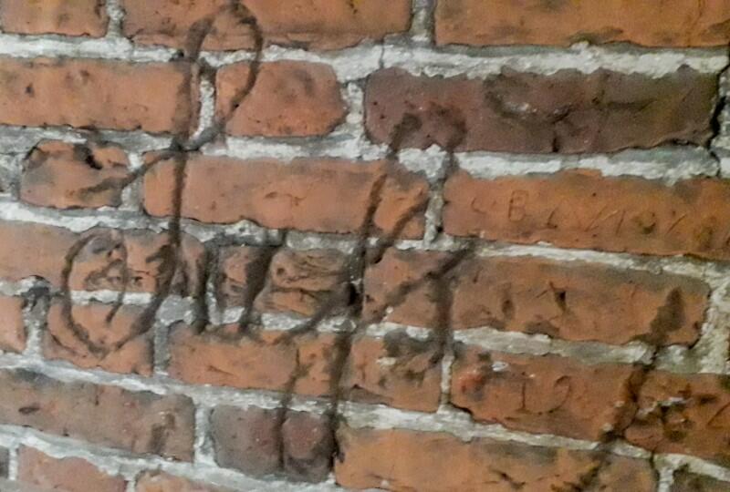 Inskrypcje odkryte na murach Wielkiego Młyna. [Na zdjęciu] To prawdopodobnie nazwisko autora inskrypcji, charakterystyczne dla XIX w. pismo pokrywa kilka cegieł