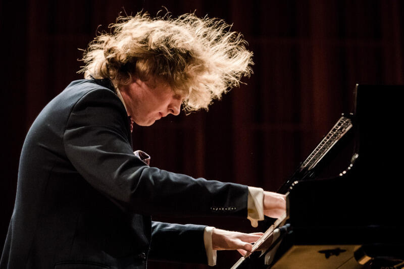 Na zdjęciu Piotr Pawlak, młody pianista z Gdańska grający na fortepianie w sali koncertowej.