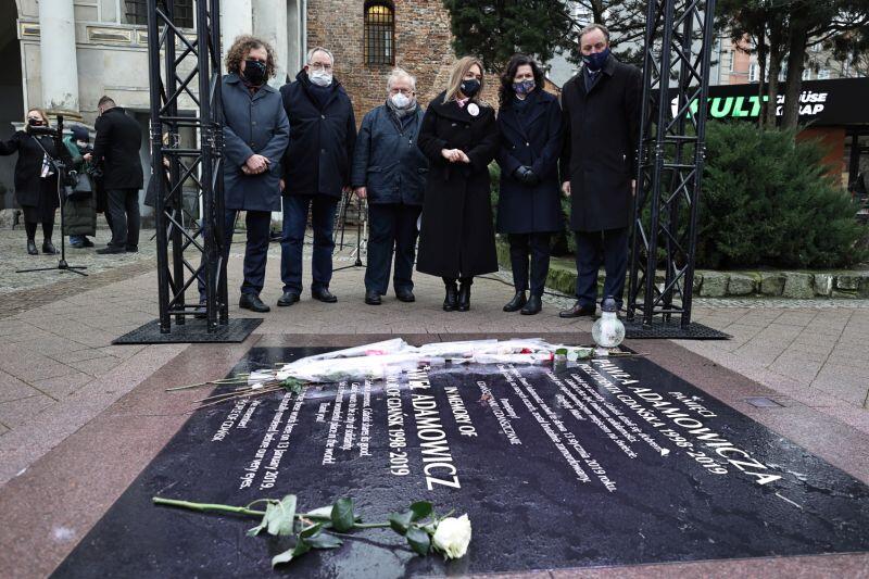 Uczestnicy konferencji przy tablicy upamiętniającej miejsce śmierci Pawła Adamowicza