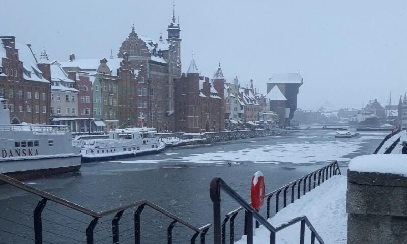 Motława na odcinku z widokiem na zabytkowy Żuraw Gdański. Rzeka częściowo przykryta warstwą bieli, ale chyba jeszcze nie lodu. Nabrzeże zaśnieżone, dachy domów też pokryte bielą
