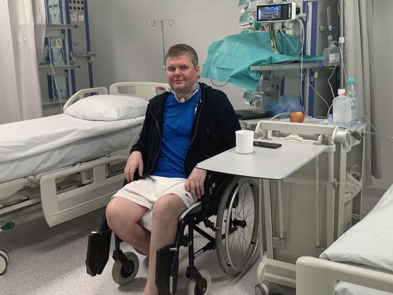 Mężczyzna w średnim wieku na wózku inwalidzkim, w szpitalnej sali 