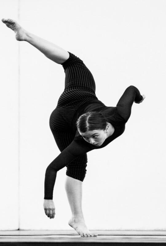 czarno białe zdjęcie, tańcząca młoda kobieta ubrana w czarny strój